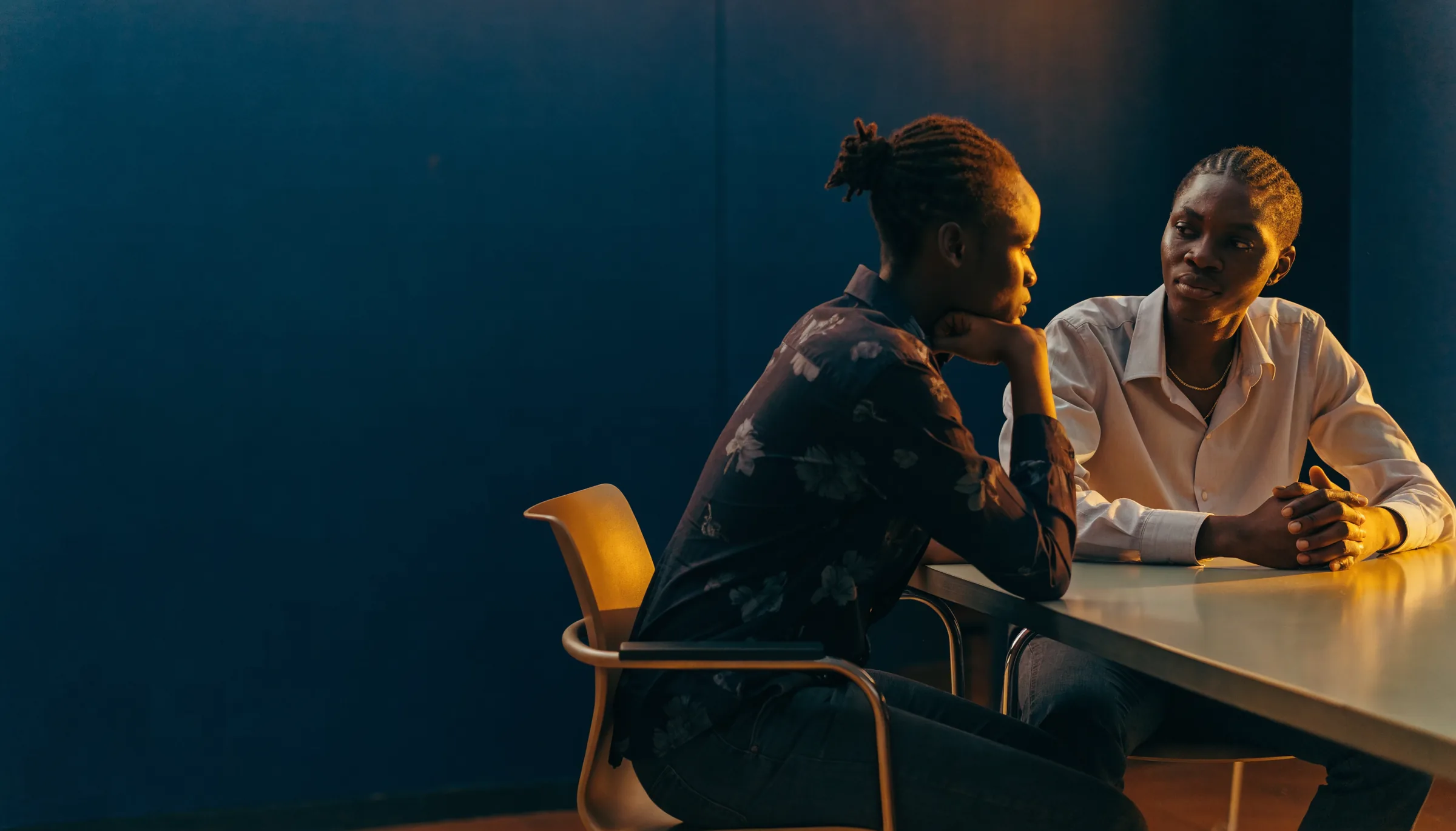 Two ICB colleagues talking across a table in the Accra office.